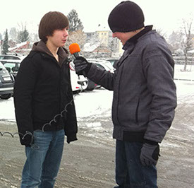 Interview im Schnee: Zwei Jugendliche drehen eine Reportage mit Mikrofon