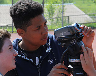 Schüler richtet die Videokamera auf dem Stativ für eine Dokfilm-Aufnahme ein