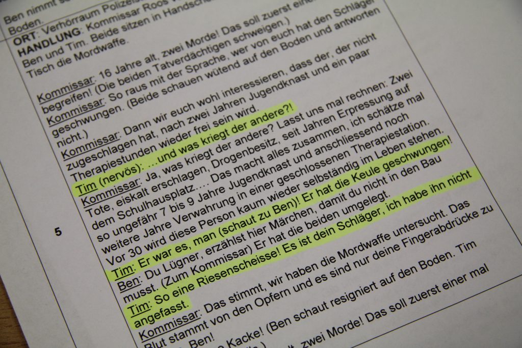 Drehbuch einer Tatort-Szene im Verhörraum mit markierten Textstellen