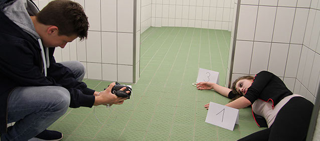 Tatort-Workshop: Ein Schüler fotografiert den Tatort, das «Opfer» liegt mit Beweisnummern am Boden
