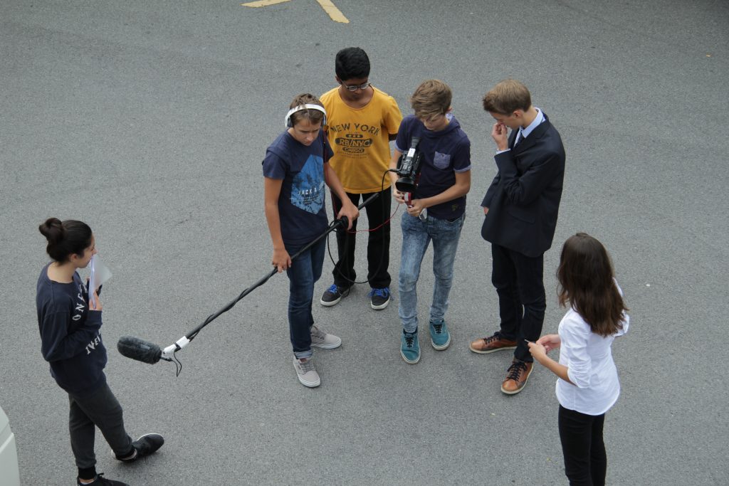 Tonaufnahme auf dem Pausenplatz: Schülerinnen und Schüler mit Tonangel und Kopfhörern