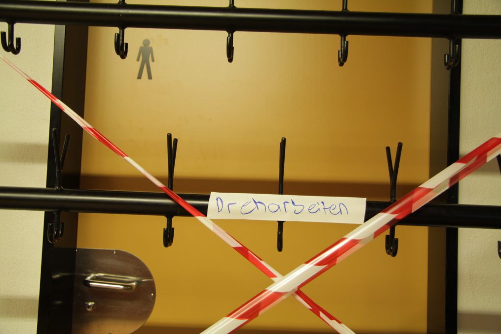 Absperrband mit Schild «Dreharbeiten» an der Garderobe im Schulhaus